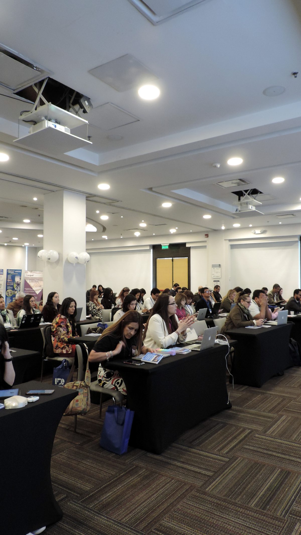 Sala llena de empresarios trabajando en sus portátiles durante un entrenamiento