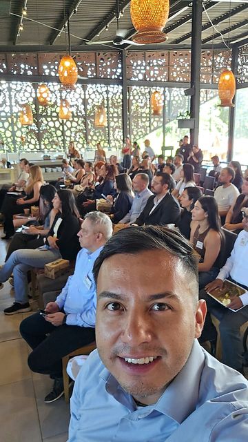 Jonathan Amaya López con el auditorio lleno detrás, en un evento empresarial